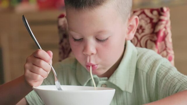 Boy 7 years green shirt close up eating spaghetti missing front teeth orthodontic plate food slurping challenge macro child expression dental issue real kid eating difficulty face struggle pasta