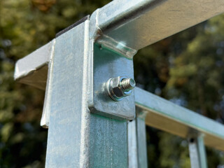 Closeup of stainless steel construction joint with bolt and nut, detail of metal frame connection...