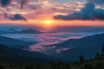 Fototapeta premium Sunrise over mist-filled mountain valley with layered peaks and dramatic clouds creating a serene and majestic atmosphere