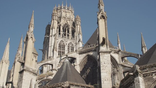 Beautiful architecture of Rouen Cathedral in France. Birds flying over the facade of the beautiful cathedral in the tourist city.