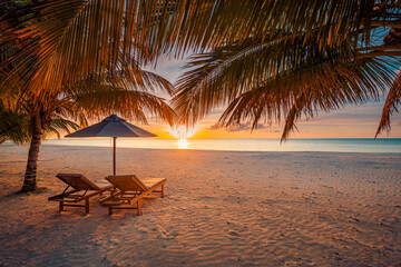 Peaceful summer sunset landscape with beach chairs and umbrella under tropical palm leaves, stunning luxury vacation scenery, relaxing ocean view, exotic travel destination, perfect tropical getaway