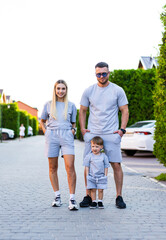 Family in matching outfits outdoors. Family enjoys a sunny day in matching gray outfits while...