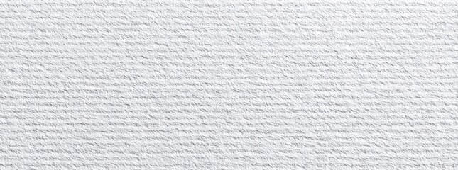 Close-up view of a white textured fabric or paper, with a repeating pattern of fine lines