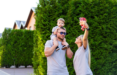 Family enjoying a sunny day in the park. A family takes a joyful selfie together in a park while...