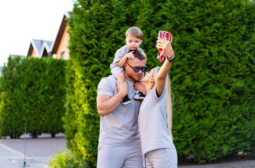 Family has fun outside. A family takes a selfie in a sunny outdoor setting, capturing a joyful...
