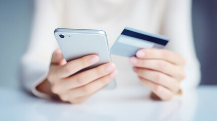 Mobile phone and credit card in hands for secure online payment and banking transaction with blurred background