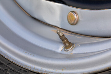 Valve stem on farm tractor tire. Tire pressure, soil compaction, and agriculture equipment maintenance and repair concept.