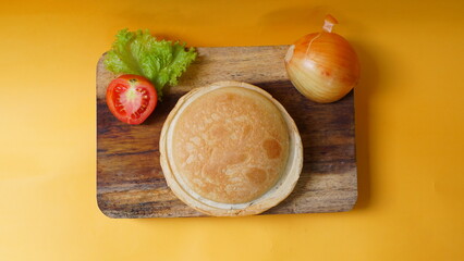 A UFO-shaped burger filled with vegetables, onions, and ground beef served with chili sauce. Healthy food.