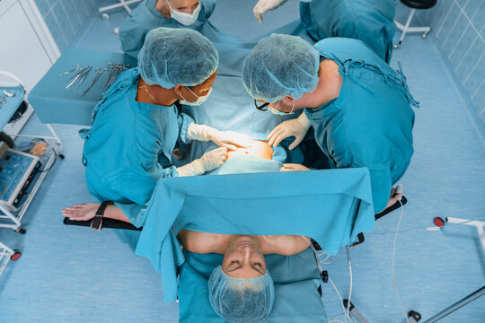 Medical Team Performing Surgery in a Sterile Operating Room with Patient Undergoing Procedure