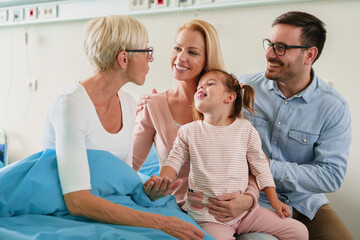 Obraz premium Sweet Family Sharing a Heartfelt Moment with Grandmother During Hospital Visit