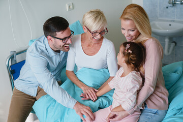 Fototapeta premium Sweet Caucasian Family Visiting Grandmother in a Hospital Room Sharing Laughter and Love Together