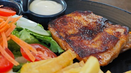 Chicken steak with salad, french fries, ketchup and mayonnaise.