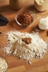 Whey protein powder, ground oat flakes, nut butter and raw cacao - ingredients for homemade protein...