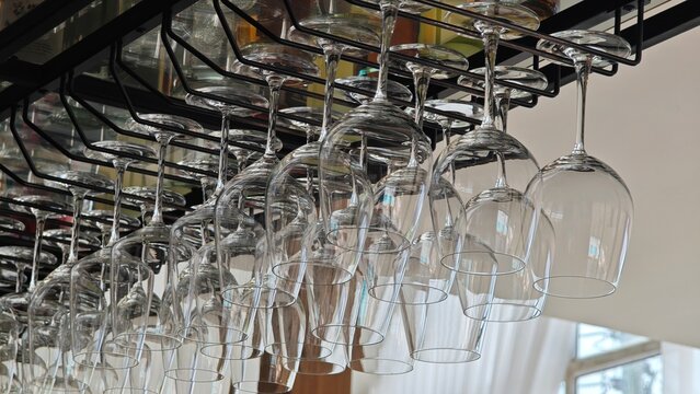 Wine glasses hanging in holder. Bar racks.