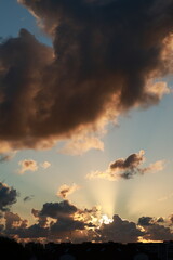 landscape of a stormy sky at sunset, heavy black clouds through which a ray of sunlight breaks through