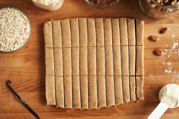 Homemade no-bake healthy bars made of whey protein powder, hazelnut butter, and ground oat flakes