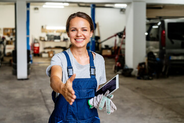 Friendly female auto mechanic greeting client in local auto repair.