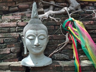 Peaceful profile of a Buddha statue adorned with a vibrant scarf