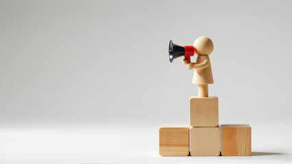 A wooden figure stands on blocks, holding a megaphone, symbolizing communication and leadership in a minimalist setting.