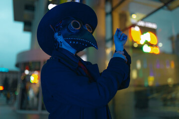 A man in a traditional plague doctor mask, hat and black suit. Dramatic portrait. Ideal for themes...
