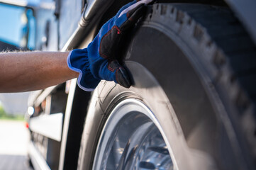 Hand Inspecting a Truck Tire During Maintenance at a Service Garage