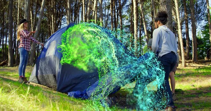 Friends lifting and draping rainfly on camping tent with swirling particle effect aiding shelter