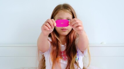 Young girl is holding an anti-snoring patch in front of her, illustrating its use and benefits, while promoting the significance of learning to breathe through the nose for improved sleep and health