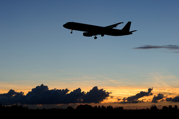 美しい太陽・光・雲・空を背景に飛ぶ航空機