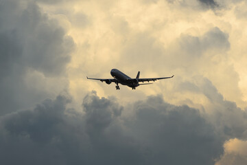 美しい太陽・光・雲・空を背景に飛ぶ航空機