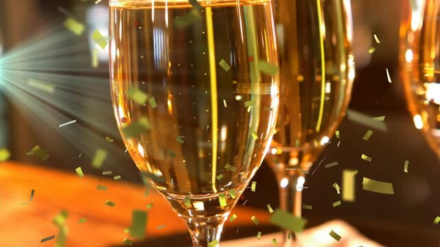 Animation of light trails and confetti over glasses of champagne