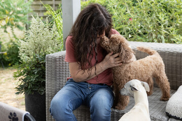 Frau mit ihren Hunden auf der Terrasse