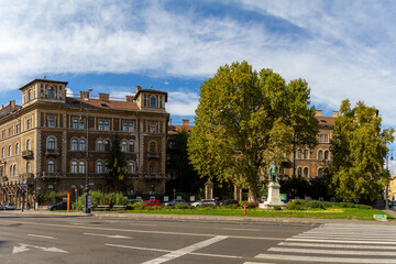 View of Andrássy Avenue square with green trees, showcasing magnificent MÁV apartment house...