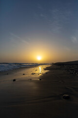 Sunset view from the beach of Maspalomas in a clear sky, in Gran Canaria Spain.