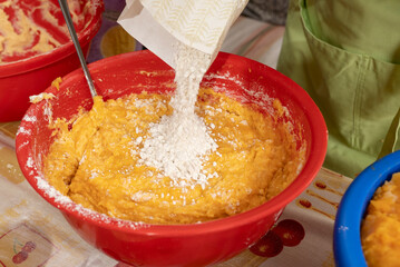 Adding flour to a potato and sweet potato dough to make fritters. Bunyols, typical food of Mallorca