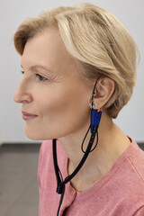 Audiologist setting a hearing aid for a client, ensuring optimal performance and comfort. Hearing...