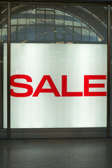 beleuchtetes Schaufenster mit der Aufschrift Sale als Hinweis auf Sonderangebote