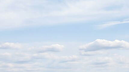 Fototapeta premium Light blue sky with scattered puffy white clouds