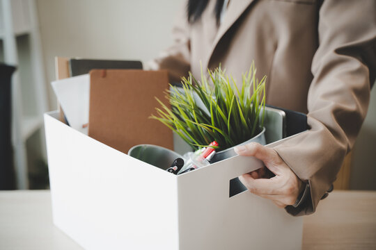 Unemployment ,jobless crisis, worker layoff concept, Close-up of young businessman pack stuff off the desk and holding boxes of self stuff when quitting the job after send resign letter from company