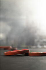 Weights and a bar lie flat on the gym floor following an intense workout session. The equipment...