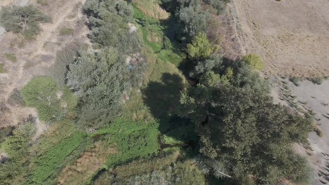 Paso Robles Homeless Encampment Aerial &mdash; Top down view of a tent in a dry riverbed, RAW LOG ungraded footage for documentary