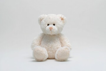 Obraz premium White teddy bear sitting on a plain white background, showcasing its soft fur and gentle expression, perfect for children's rooms or gift occasions and evoking feelings of comfort