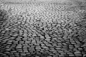 Old square cobble stone with green grass. paving perspective background.Paving stone pavement texture. Cobblestone pavement. stone sidewalk. texture. Cobble stone road cobble texture. perspective