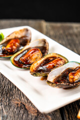 Mussels in oyster sauce on a dark background. Asian food. Chinese cuisine