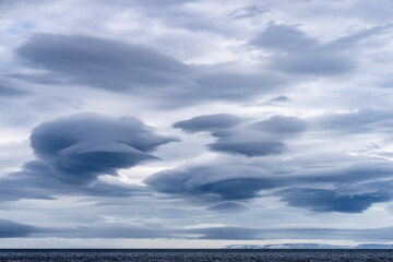 Dramatic lenticular clouds above Svalbard, a striking natural phenomenon enhancing the raw beauty...
