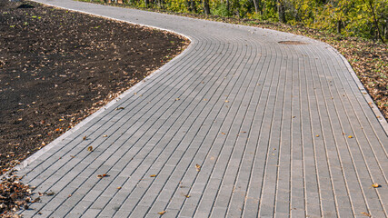 Paving slabs for paths. Paving slabs made of cement mix. Paving stones made of artificial materials. Laying tiles on the road. Material for covering sidewalks and streets. Repair of sidewalks