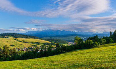 Obraz premium Scenic rural landscape with golden fields and green forests stretching towards the Tatra Mountains. A tranquil view capturing the beauty of nature and traditional farming land.