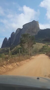 pov: carro trafegando em estrada rural com monumento de pedra ao fundo. Monumento &eacute; conhecido como Cinco Pont&otilde;es, localizado entre Laranja da Terra e Itagua&ccedil;u, no Espirito Santo