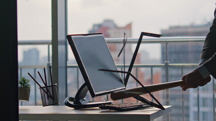Unknown businessman smashing computer screen using bat inside office closeup