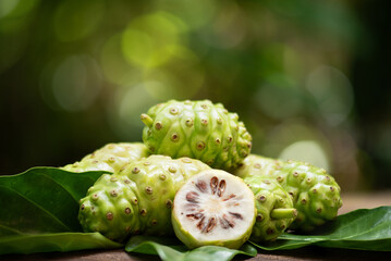 Noni or Morinda citrifolia fruits on the natural background.