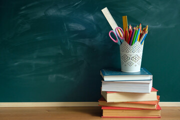 books and school stationery on table, chalk blackboard. symbol of beginning of the school year,...